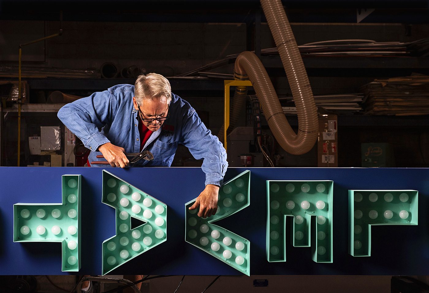 sign worker creating a sign in the factory